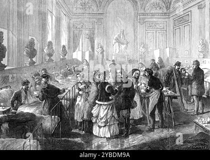 Ambulanza al Theatre Fran&#xe7;ais, Parigi, 1871. Guerra franco-prussiana: '...military ospedale estemporto nella hall pubblica del Teatro Fran&#xe7;ais...la statua di Voltaire...si vede sullo sfondo...i letti dei soldati feriti sono disposti su entrambi i lati...il panno allungato dietro la fila di letti mostra la croce rossa del servizio ospedaliero da campo, e un cartello recante il nome scritto del soldato posato in ogni letto. La signora infermiera, con i riccioli, al terzo letto a sinistra, che offre un bacino di brodo al tenente che ha il braccio in una fionda, è Mdlle. Marquet, lo è Foto Stock