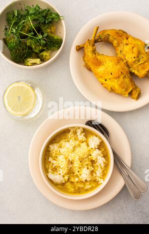 Coniglio stufato con riso, broccoli, servito a tavola con cibo, pranzo o cena delizioso e sostanzioso Foto Stock