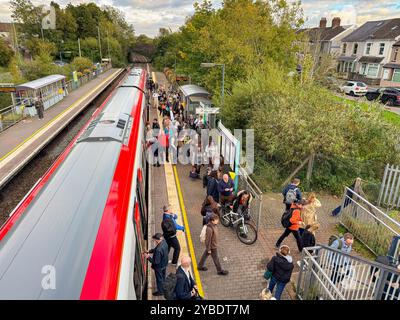 Pontyclun, Galles - 1 ottobre 2024: Le persone che scendono e salgono a bordo di un treno pendolare Transport for Wales Class 197 si fermano alla stazione del villaggio Foto Stock