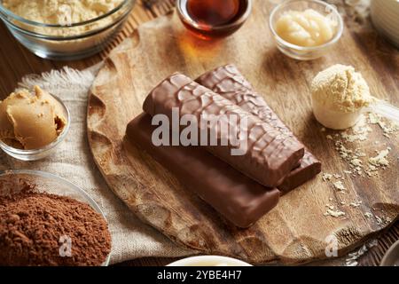 Barrette di cioccolato proteiche con ingredienti - proteine del siero di latte in polvere, burro di arachidi, cacao crudo, miele e sciroppo d'acero Foto Stock