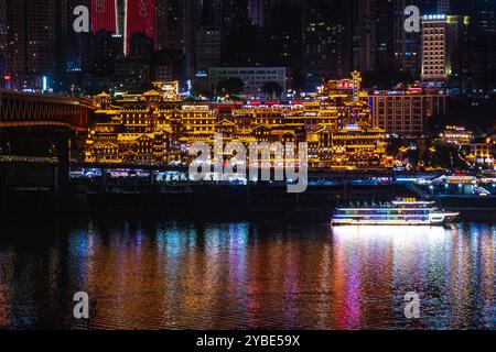 La vista notturna mozzafiato della grotta di Chongqing Hongya e del suo vivace quartiere commerciale l'ha resa una destinazione imperdibile per i turisti. Foto Stock