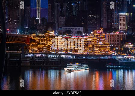 La vista notturna mozzafiato della grotta di Chongqing Hongya e del suo vivace quartiere commerciale l'ha resa una destinazione imperdibile per i turisti. Foto Stock