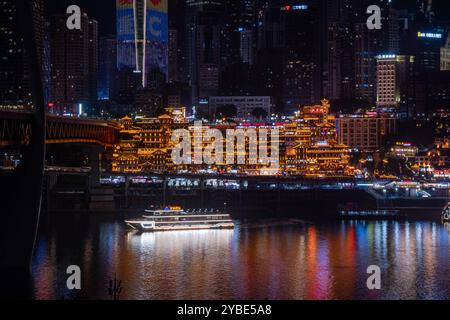 La vista notturna mozzafiato della grotta di Chongqing Hongya e del suo vivace quartiere commerciale l'ha resa una destinazione imperdibile per i turisti. Foto Stock