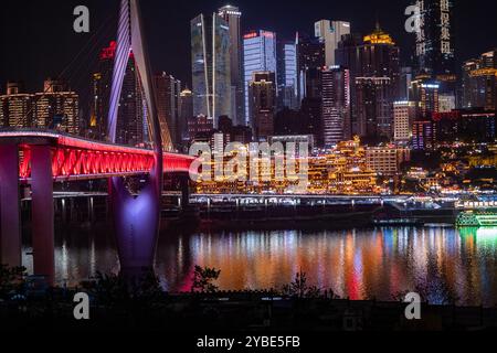 La vista notturna mozzafiato della grotta di Chongqing Hongya e del suo vivace quartiere commerciale l'ha resa una destinazione imperdibile per i turisti. Foto Stock