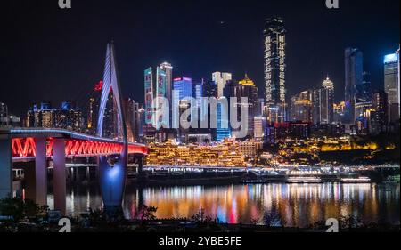 La vista notturna mozzafiato della grotta di Chongqing Hongya e del suo vivace quartiere commerciale l'ha resa una destinazione imperdibile per i turisti. Foto Stock