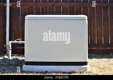 Gruppo elettrogeno domestico di standby in cortile residenziale, alimentazione elettrica di riserva di emergenza generazione di elettricità. Foto Stock