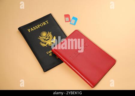 Moderne schede SIM e passaporto su sfondo beige Foto Stock