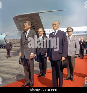 Il presidente degli Stati Uniti John F. Kennedy in piedi con il Cancelliere della Germania Ovest, Konrad Adenauer (primo piano), e il ministro federale della difesa della Germania Ovest, Kai-Uwe von Hassel; ispettore generale della Bundeswehr, generale Friedrich A. Foertsch (sfondo immediato), durante la sua cerimonia di arrivo, aeroporto Wahn, Bonn, Germania Ovest, Robert Knudsen, White House Photographs, 23 giugno 1963 Foto Stock