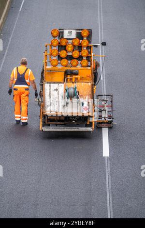 Lavori di marcatura dopo l'applicazione di una nuova superficie di asfalto sussurro per l'autostrada A40, nella città di Essen, in direzione Dortmund, 95.000 metri quadrati Foto Stock