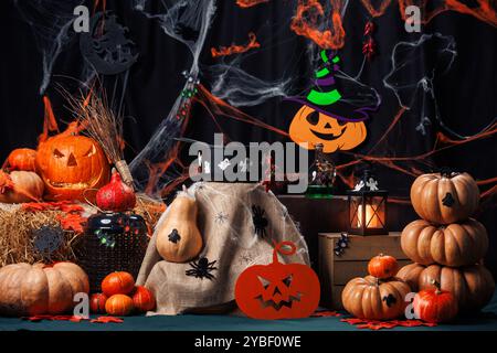 Zucche, fieno, scopa, calderone, fantasmi. Area fotografica per Halloween, decorazioni e oggetti di scena, vacanze autunnali. Foto Stock