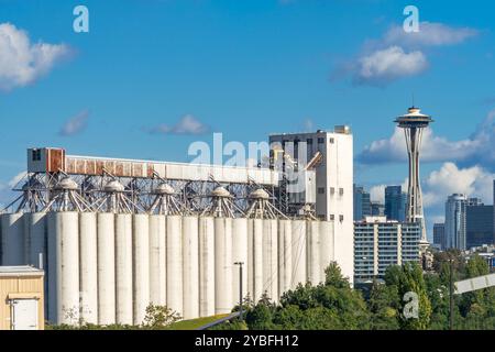 Seattle, Washington, Stati Uniti - 20 settembre 2024: Silos presso il terminal 86 dell'impianto grano con lo Space Needle sullo sfondo a Seattle, Washington. Foto Stock