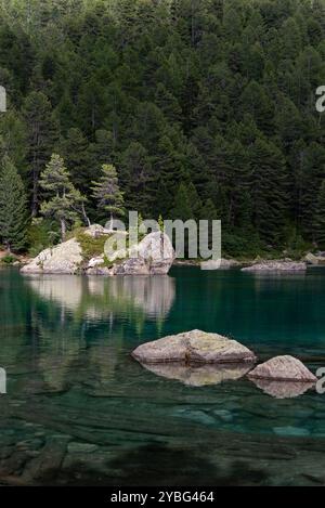 Vista panoramica alpina del lago Saoseo con riflessi e paesaggio montano robusto in Svizzera Foto Stock