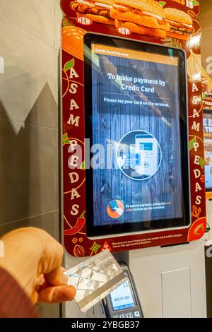 Terminale con carta di credito/debito per il pagamento, a Burger King, Tiong Bahru Singapore - "per effettuare il pagamento con carta di credito tocca la tua carta sul terminale" Foto Stock
