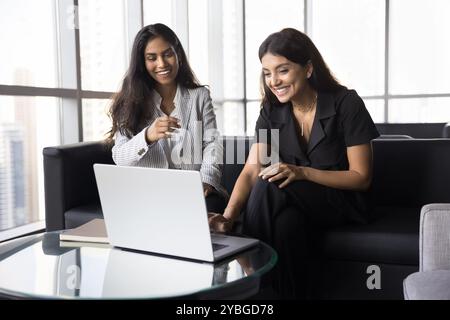 Due allegra giovane donna professionista multietnica che si diverte a lavorare di squadra Foto Stock