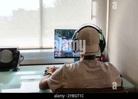 Madrid, Spagna, 15 agosto 2018: Teenager che gioca al videogame Fortnite su PC. Sta alzando il pugno in un gesto di vittoria. Fortnite è un multiplo online Foto Stock