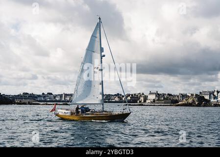 Roscoff, Francia, 31 luglio 2018: Barca a vela nella baia di Roscoff contro il lungomare della città, Europa Foto Stock