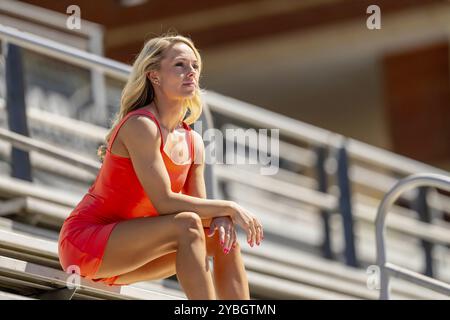 Un radioso atleta bionda brilla in pista in una giornata straordinaria, incarnando forza e grazia a ogni passo Foto Stock