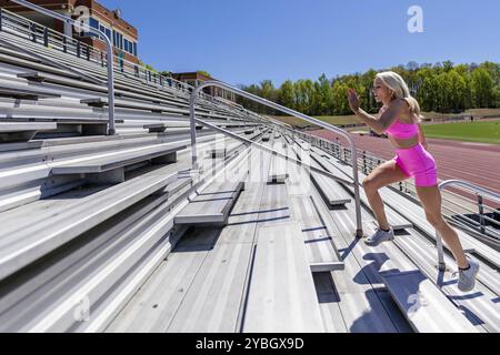 L'atleta bionda dà energia, facendo correre le candeggine preparandosi all'incontro locale, incarnando forza e determinazione Foto Stock