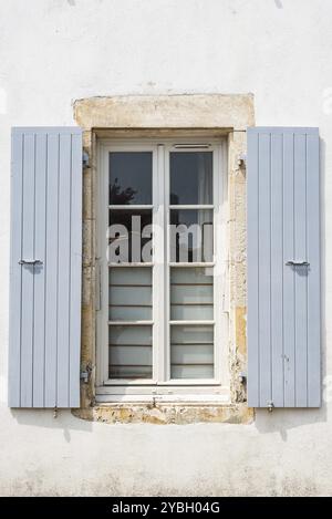 Vecchia finestra con legno verniciato grigio ante aperte sul muro bianco della tradizionale hpuse nell'isola di Re Foto Stock