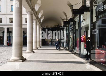 Londra, Regno Unito, 15 maggio 2019: Vista del colonnato della Royal Opera House nell'area di Covent Garden. Covent Garden è rinomata per la sua lussuosa moda e bellezza Foto Stock