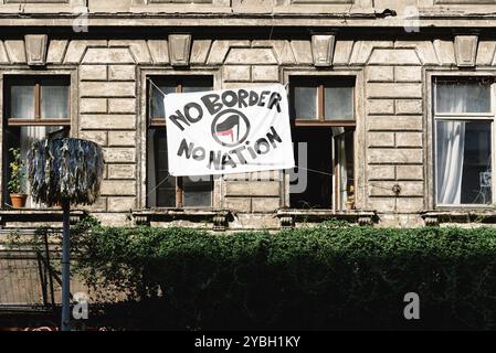 Berlino, Germania, 28 luglio 2019: Edificio abbandonato e occupato con striscione anarchico con il testo: Nessun confine, nessuna nazione, Europa Foto Stock