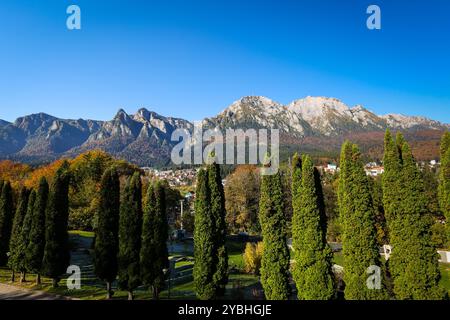 I monti Bucegi e il picco Caraiman sullo sfondo e la città di Busteni durante una giornata di sole autunno. Foto Stock