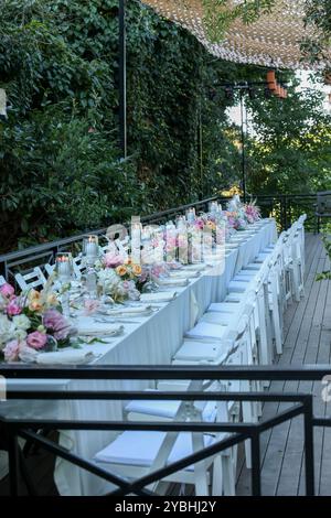 Elegante e minimalista disposizione del tavolo da sposa con eleganti decorazioni floreali, ideale per feste moderne Foto Stock