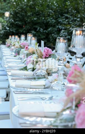 Elegante e minimalista disposizione del tavolo da sposa con eleganti decorazioni floreali, ideale per feste moderne Foto Stock