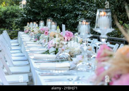 Elegante e minimalista disposizione del tavolo da sposa con eleganti decorazioni floreali, ideale per feste moderne Foto Stock