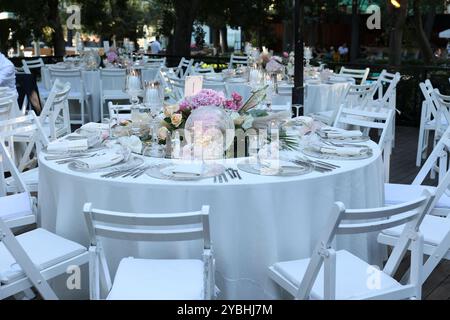 Elegante e minimalista disposizione del tavolo da sposa con eleganti decorazioni floreali, ideale per feste moderne Foto Stock