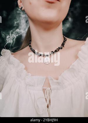 Choker nero in ossidiana con ciondolo albero della vita sul collo della donna Foto Stock