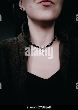 Girocollo nero in ossidiana con pendente albero della vita sul collo della donna collana grossa in pietra naturale con fascino albero della vita donna senza faccia da vicino Foto Stock