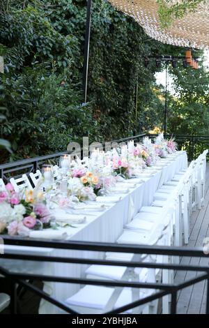 Elegante e minimalista disposizione del tavolo da sposa con eleganti decorazioni floreali, ideale per feste moderne Foto Stock