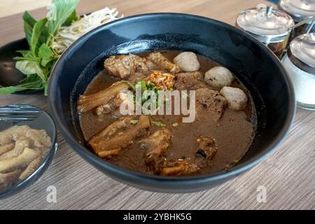 Spaghetti di manzo tailandese di prima qualità in salsa di soia scura, cagliata di fagioli sottaceto e altra zuppa di spezie servita con polpetta, tendine e gambo brasato. BU Foto Stock