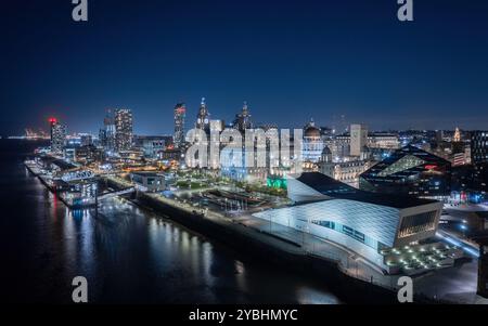 Vista aerea del lungomare di Liverpool di notte, con Pier Head, le Three Graces e gli edifici illuminati lungo il fiume Mersey. Foto Stock