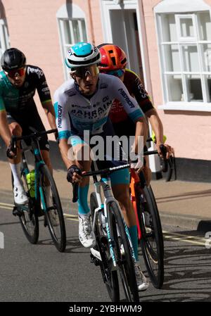 Nella fase finale del Tour of Britain 2024, passando per Framlingham nel Suffolk, un gruppo ad interim di quattro piloti sta inseguendo la pausa di testa. Foto Stock