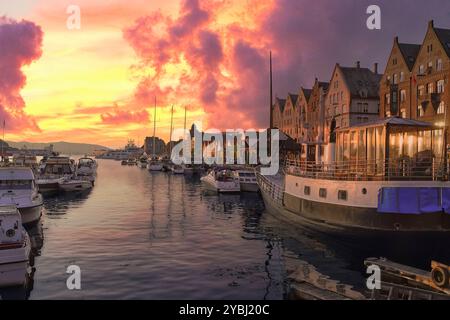 7 settembre 2024 Bergen, Norvegia il sole tramonta sul porto di fronte ai colorati magazzini convertiti nel quartiere Bryggen Hansa, Bergen, Norw Foto Stock