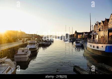7 settembre 2024 Bergen, Norvegia il sole tramonta sul porto di fronte ai colorati magazzini convertiti nel quartiere Bryggen Hansa, Bergen, Norw Foto Stock