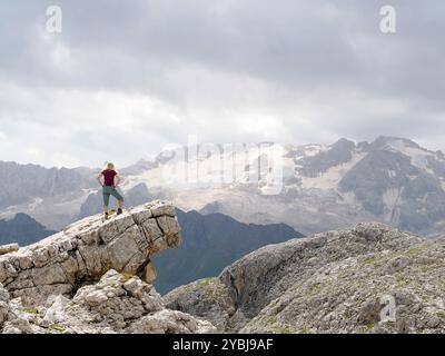 Una veduta dal retro della donna che circonda una veduta panoramica del ghiacciaio della Marmolada, la vetta più alta delle Dolomiti, Italia in estate Foto Stock