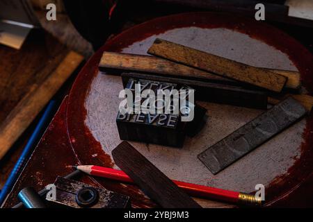 Close-up di alfabeti e numeri in rilievo nel vassoio in officina Foto Stock