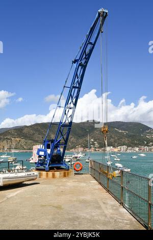 Gru blu sul molo del porto turistico della Baia delle fiabe, con la costa sullo sfondo, Sestri Levante, Genova, Liguria, Italia Foto Stock