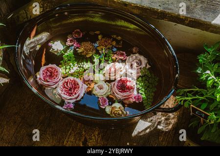 fiori di rosa galleggianti in una vasca d'acqua Foto Stock