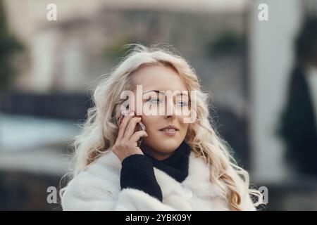 Una donna elegante cammina attraverso una storica città europea, parlando con il suo smartphone, mescolando la tecnologia moderna con la ricca storia della città Foto Stock