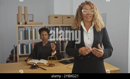 Donne che lavorano insieme in uno studio legale con una come giudice e l'altra come avvocato, discutendo questioni legali. Foto Stock
