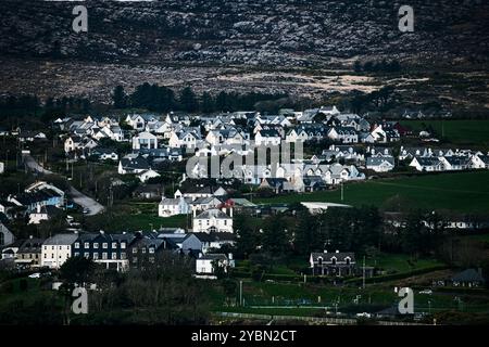 Una vista panoramica di una città annidata tra colline ondulate. La città presenta un mix di edifici residenziali di diverse dimensioni e colori. C'è un Foto Stock