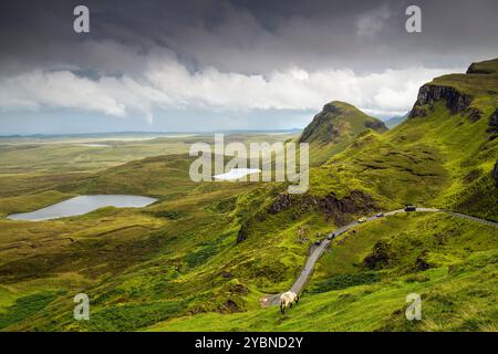 Auto che viaggiano su strada attraverso il Quiraing sull'isola di Skye, Scozia, Regno Unito Foto Stock