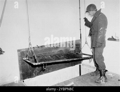 Un soldato americano testa l'ascensore del crematorio durante un'ispezione del campo di concentramento di Natzweiler-Struthof. Foto Stock