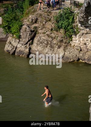 Batumi, Georgia. 08.19.2024 Adjara montuosa. Un RAGAZZO si tuffa in un FIUME dopo essere saltato da una scogliera. ESTREMA. Gente in vacanza. Ragazzi che saltano dentro Foto Stock