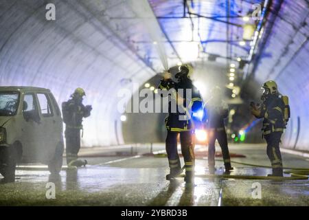 Jena, Germania. 20 ottobre 2024. In uno scenario di emergenza, un'auto sta andando a fuoco nel tunnel. I vigili del fuoco si esercitano a spegnere il veicolo. Esercitazione importante nel tunnel di Jagdberg sulla A4 tra gli svincoli "Bucha" e "Jena-Göschwitz" nella notte del 19/20 ottobre 2024. Nell'esercitazione sono coinvolti circa 200 vigili del fuoco, protezione civile e polizia autostradale. Crediti: Jacob Schröter/dpa/Alamy Live News Foto Stock