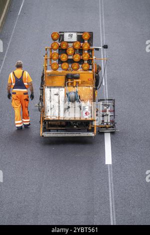 Lavori di marcatura dopo l'applicazione di una nuova superficie di asfalto sussurro per l'autostrada A40, nell'area urbana di Essen, direzione Dortmund, 95, 000 quadrato Foto Stock